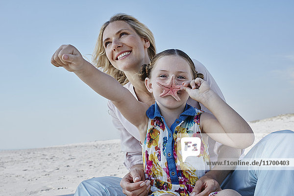Glückliche Mutter mit Tochter am Strand