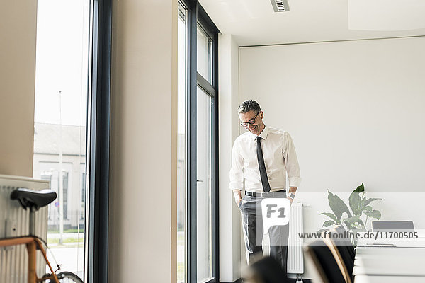 Laughing businessman standing in conference room