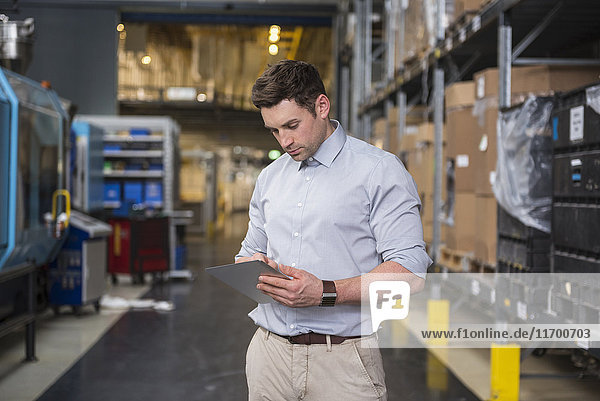 Man using tablet in factory warehouse