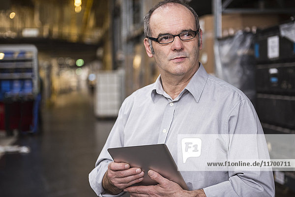 Man holding tablet in factory warehouse