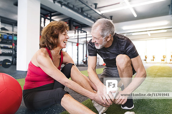 Happy senior couple exercising in gym