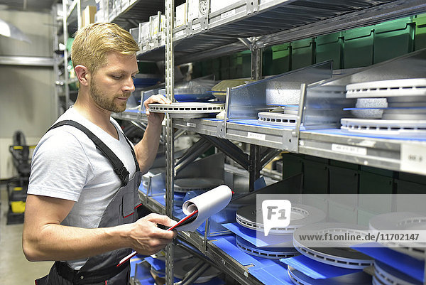 Man in warehouse looking at clipboard