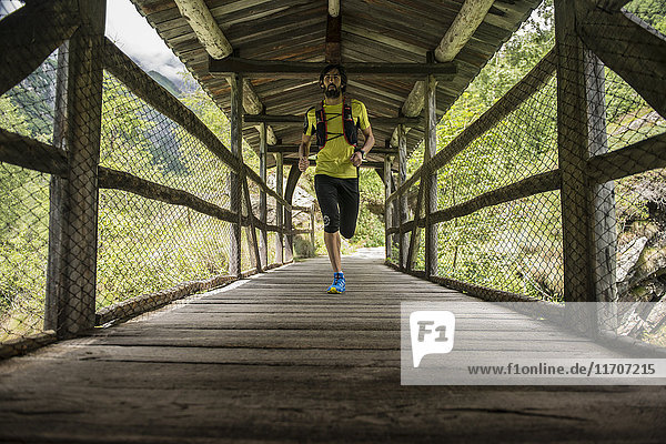 Italien  Alagna  Mann läuft auf Holzbrücke in den Bergen