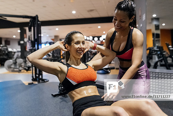 Woman with her trainer working out in gym