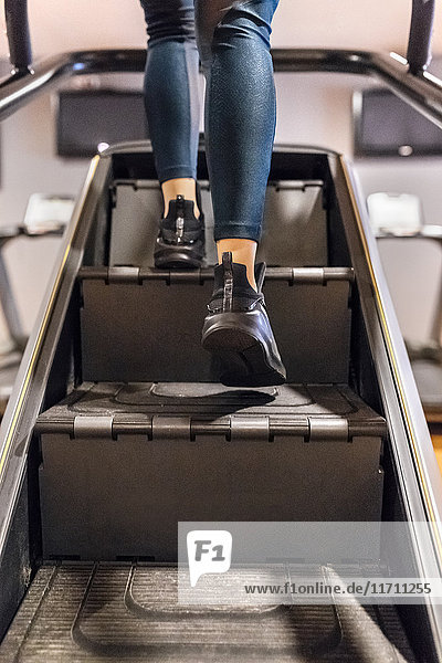 Nahaufnahme des Frauentrainings im Fitnessstudio mit einer Treppenmaschine