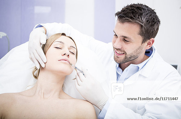Aesthetic surgery  woman receiving injection into lip