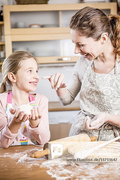 Mutter und Tochter backen gemeinsam Brot in der Küche