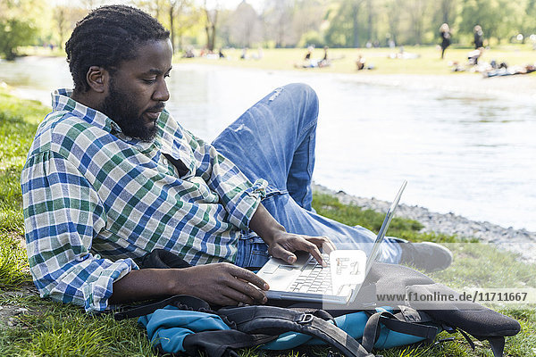 Man on a meadow using laptop