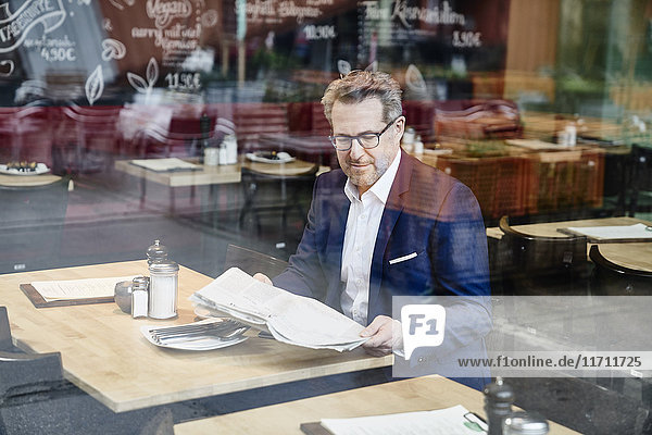 Reife Geschäftsleute im Cafe lesen Zeitung