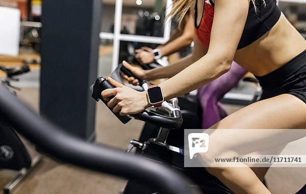 Close-up of woman on spinning bike in the gym