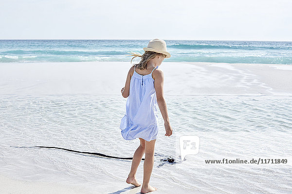 Kleines Mädchen  das am Strand spazieren geht.