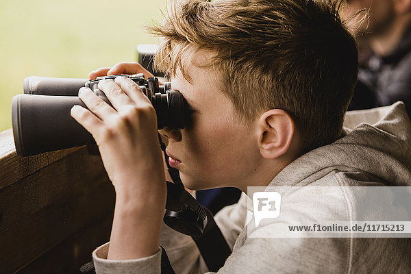 Boy birdwatching with binoculars