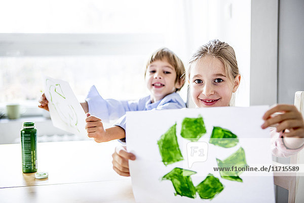 Mädchen halten Papier mit bemaltem Recycling-Symbol