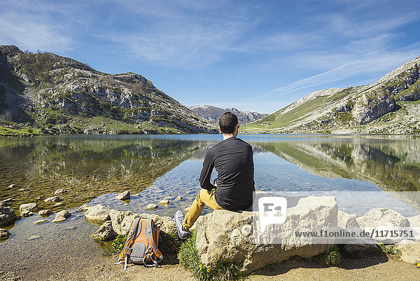 Spanien  Asturien  Picos de Europa Nationalpark  Mann sitzt am Covadonga-See