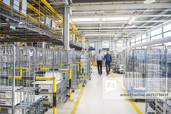 Two men walking in factory shop floor