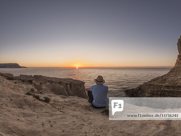 Spain  Andalusia  Cabo de Gata  back view of man looking at the sea at sunrise