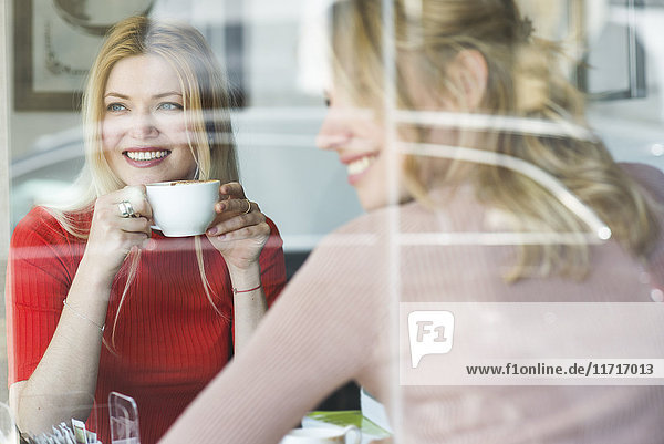 Zwei lächelnde junge Frauen in einem Cafe