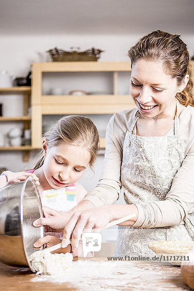 Mother and daughter baking in kitchen together