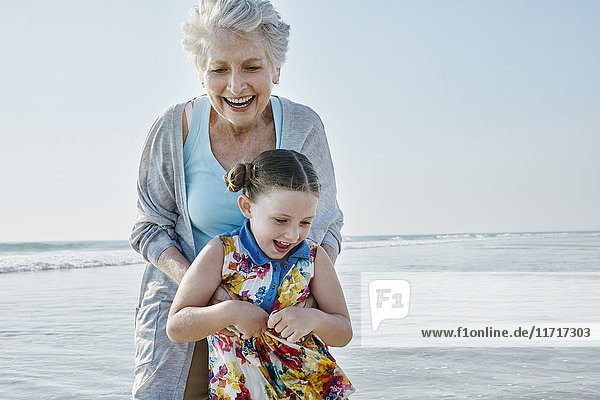 Glückliche Großmutter mit Enkelin am Strand