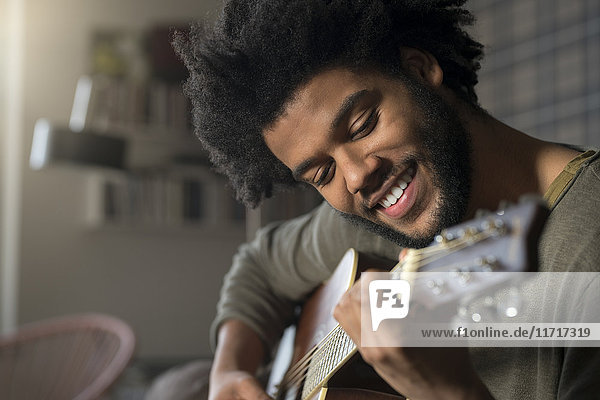 Smiling man playing guitar