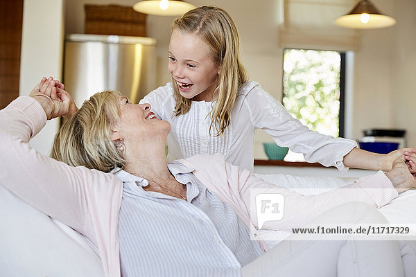 Little girl having fun with her grandmother at home