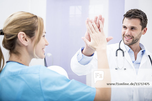 Two smiling doctors high fiving