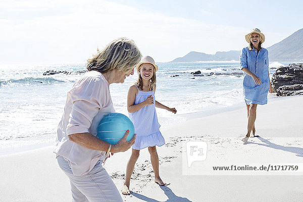 Familie beim Ballspielen am Meer