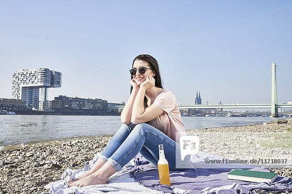 Deutschland,  Köln,  junge Frau entspannt am Rhein