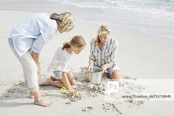 Family playing with sand on the beach