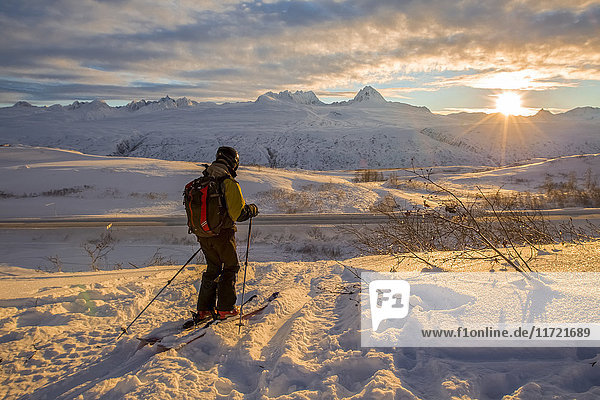 Skier watching the sunset over Richardson Highway  Thompson Pass  Southcentral Alaska  USA