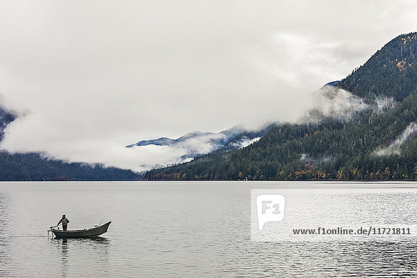 'Fisherman on Lake Crescent in traditional Willie drift boat  Olympic National Park; Port Angeles  Washington  United States of America'