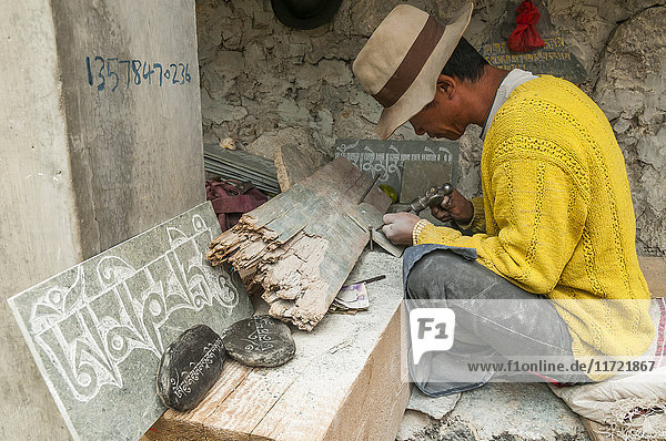 'Worker carving stones with the mantra ''om ma ni pa me hum'' Shangrila's Monastery a beautiful and famous place with more than 20 buddhist temples; Shangrila Yunnan province China.'
