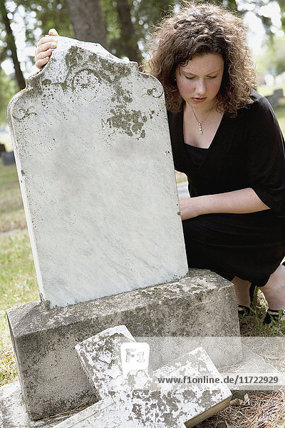 Eine junge Frau besucht einen Grabstein auf einem Friedhof; Edmonton  Alberta  Kanada .