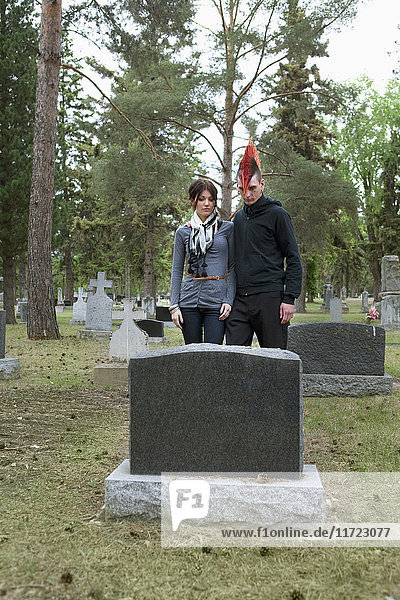 Ein junger Mann und eine junge Frau  die sich gegenseitig auf einem Friedhof unterstützen; Edmonton  Alberta  Kanada'.