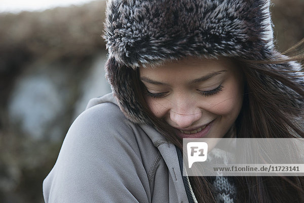 Porträt einer jungen Frau mit pelzverbrämter Mütze und Blick nach unten; Island