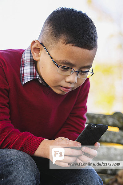 'A young boy using a smart phone; Washington  United States of America'