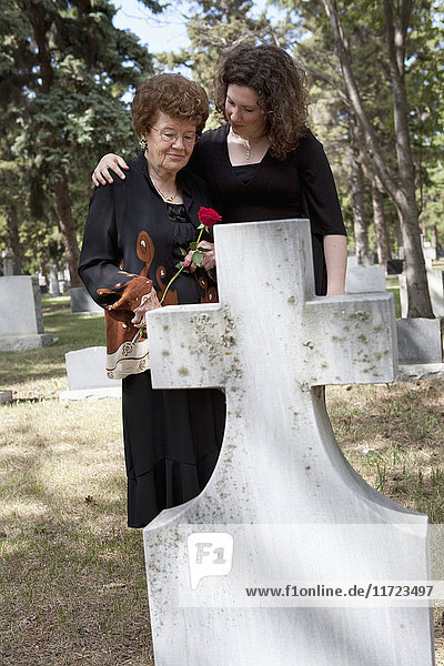 Eine Großmutter und ihre Enkelin besuchen ein Grab auf einem Friedhof in Edmonton  Alberta  Kanada.