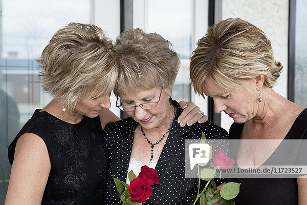 Eine Mutter und ihre beiden Töchter trauern um einen Todesfall; Edmonton  Alberta  Kanada'.