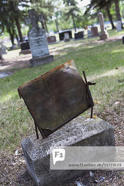 Eine verrostete Metallplatte auf einem alten Grabstein; Edmonton  Alberta  Kanada .