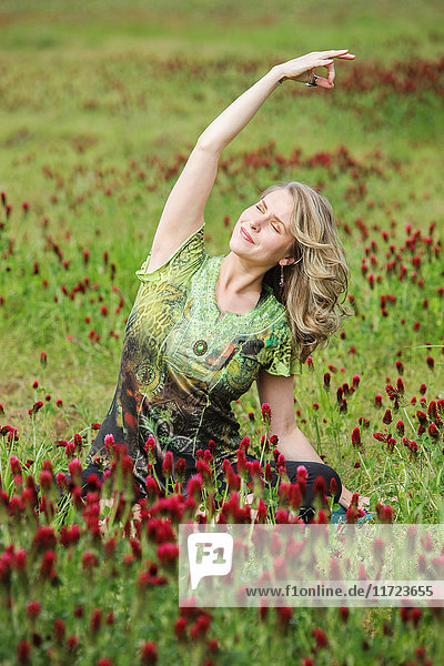 'A woman does yoga in a field of wildflowers; Oregon United States of America'