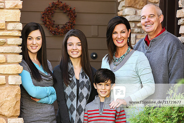Porträt einer Familie mit drei Kindern  die an der Tür ihres Hauses stehen; Oregon  Vereinigte Staaten von Amerika'.