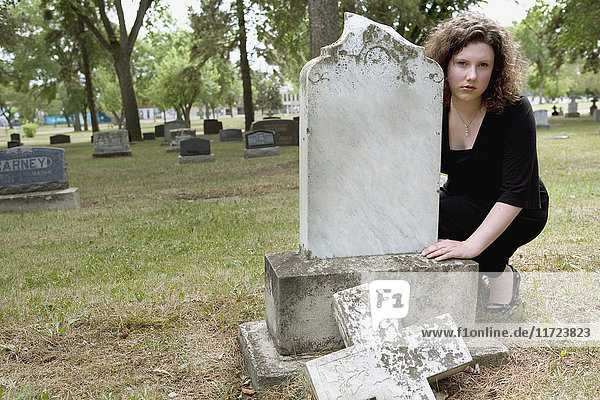 Eine junge Frau besucht einen Grabstein auf einem Friedhof; Edmonton  Alberta  Kanada .