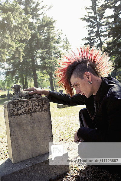 Ein junger Mann besucht einen Grabstein; Edmonton  Alberta  Kanada .