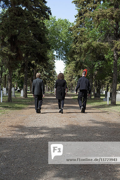 Drei junge Leute  die einen Weg auf einem Friedhof entlanggehen; Edmonton  Alberta  Kanada'.