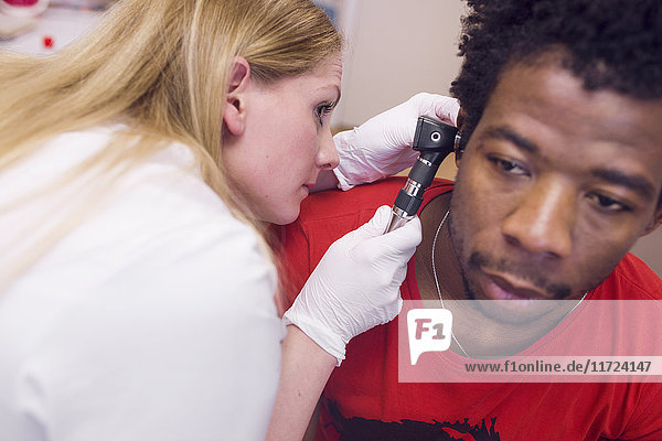 Doctor examining man's ear