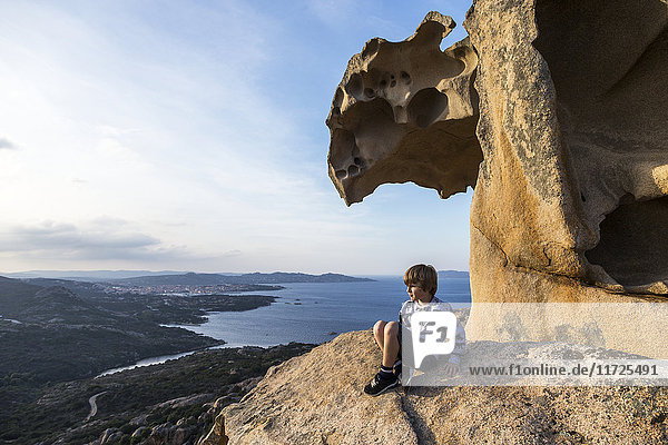 Junge auf Felsen mit Blick auf die Aussicht