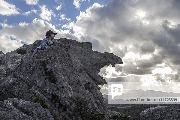 Junge auf Felsen mit Blick auf die Aussicht