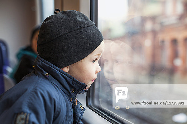 Junge schaut durch das Zugfenster