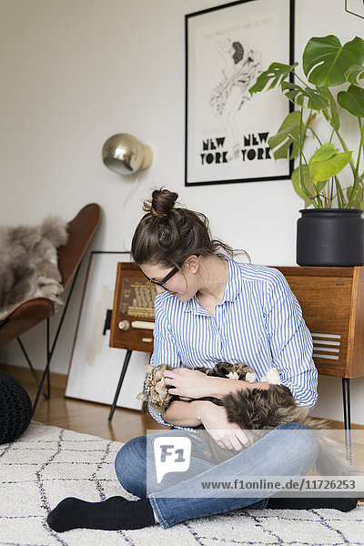 Junge Frau spielt mit Katze