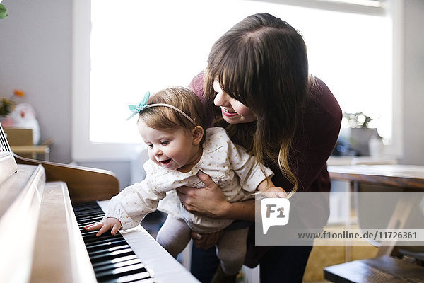 Mutter mit Tochter (12-17 Monate) beim Klavierspielen